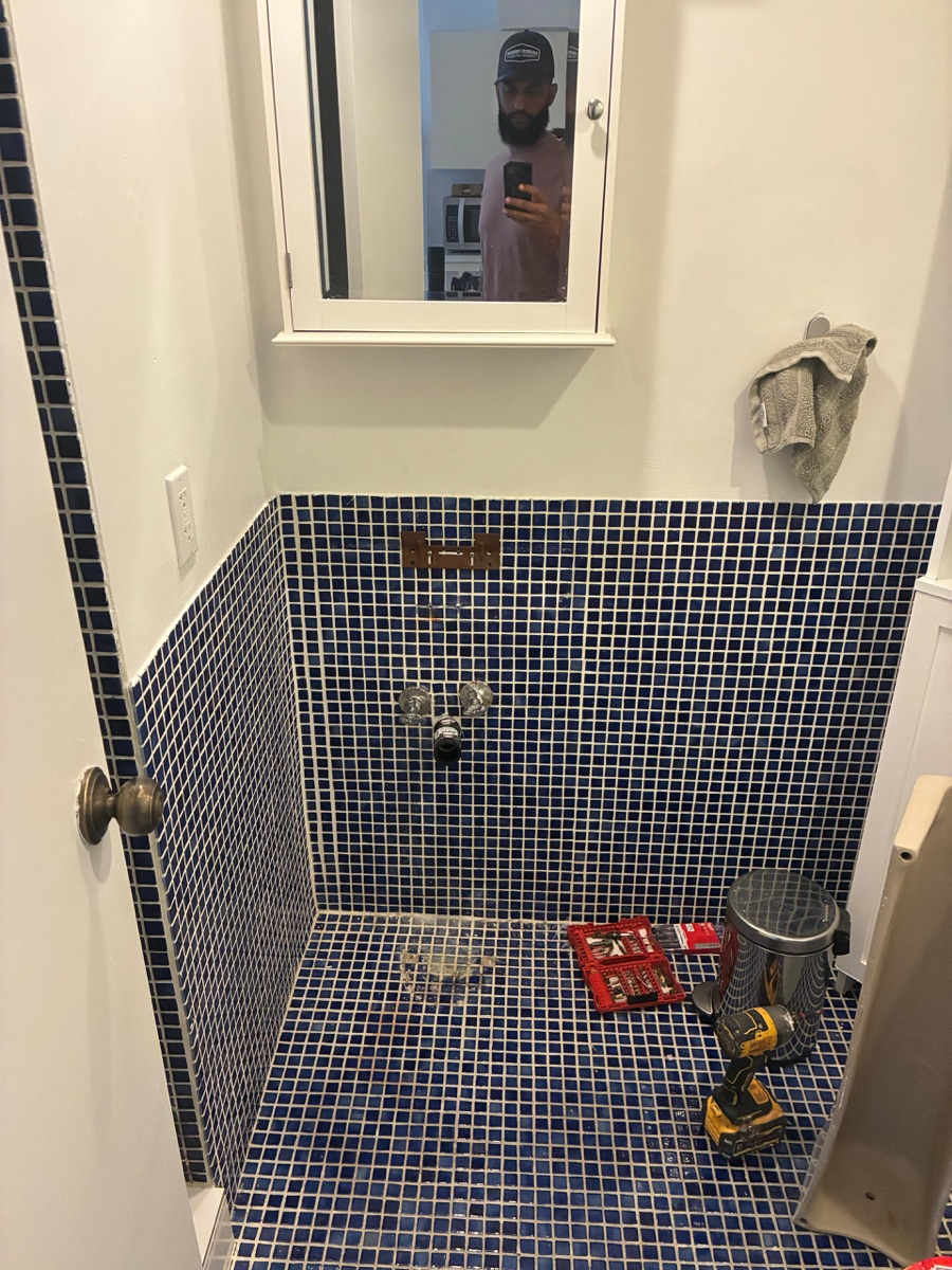 Bathroom remodel in progress — blue mosaic shower